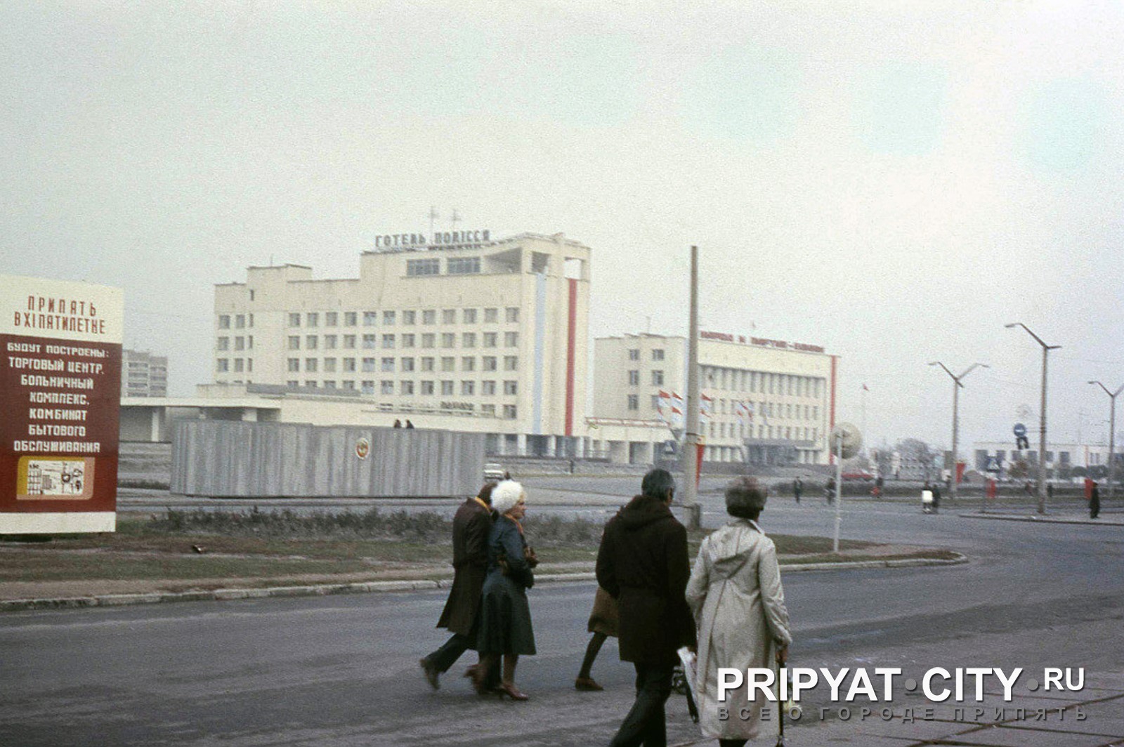 Людзі ідуць па Прыпяці на фоне гасцініцы «Палессе» і гарвыканкама, да аварыі на ЧАЭС
